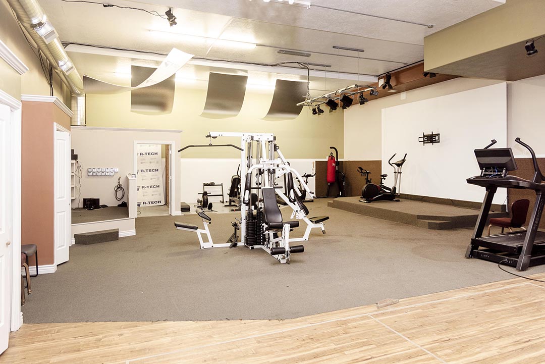 Exercise room with strength machines and cardio equipment at Traverse Recovery Center